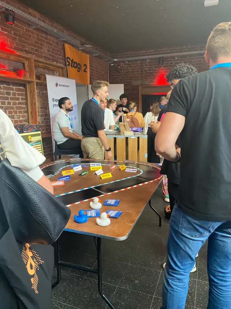 Gewinnspiel-Stand von adesso auf der koks.digital 2025 mit einer Rennstrecke auf dem Tisch.