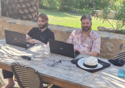 Nils Beckmann und Harald Lammers während der Arbeit unter Palmen.