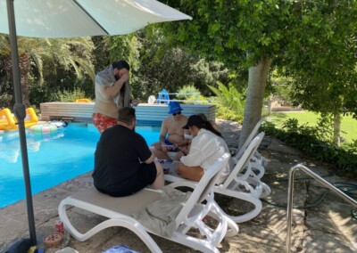 Die erste Gruppe, die sich beim Schnitzeljagd gefunden haben, treffen sich vor dem Pool.